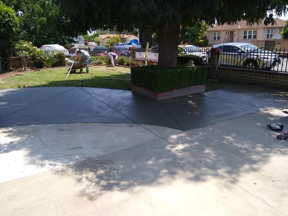 Concrete driveway being poured and finished by Campos Lawn Care crew